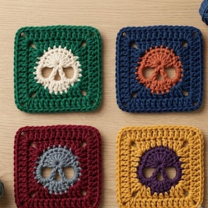 May include: Four square crochet motifs featuring a central skull design. The top left is green with a cream skull, the top right is navy with an orange skull, the bottom left is maroon with a grey skull, and the bottom right is yellow with a purple skull.