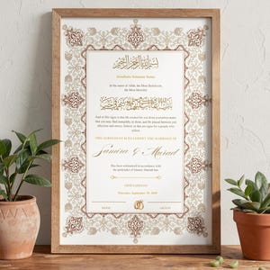 May include: A framed marriage certificate with ornate gold and burgundy patterns. The document features Arabic calligraphy and English text, including the names Samira & Murad. The frame is made of light brown wood.