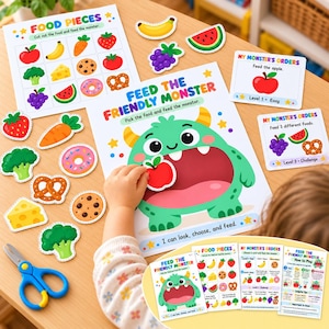 May include: A printable activity set featuring a green monster game board, food cutouts, and instruction cards. The main board displays a large green monster with an open mouth, surrounded by colorful illustrations of fruit, vegetables, and snacks.