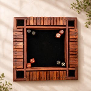 May include: A wooden Shut the Box dice game. The game board is square with a dark wood frame and a black felt playing surface. The frame has numbered blocks from 1 to 12. Several dice are scattered on the felt.