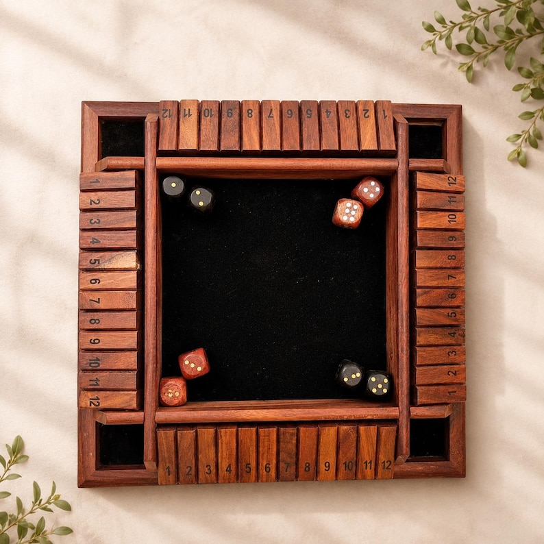 May include: A wooden Shut the Box dice game. The game board is square with a dark wood frame and a black felt playing surface. The frame has numbered blocks from 1 to 12. Several dice are scattered on the felt.