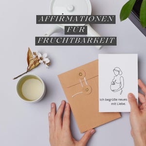 Puede incluir: Una tarjeta blanca con un dibujo lineal de una persona embarazada se sostiene frente a un sobre marrón. La tarjeta tiene el texto "Ich begrüße neues mit Liebe." Arriba, el texto dice "AFFIRMATIONEN FUR FRUCHTBARKEIT."