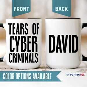 May include: A white ceramic mug with a black handle and rim. The front features the black text TEARS OF CYBER CRIMINALS in a bold sans-serif font. The back of the mug displays the black text DAVID in the same bold, capitalized sans-serif font.