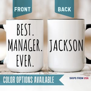 May include: A white ceramic mug with a black handle and rim. The front features the black text 'BEST. MANAGER. EVER.' in a tall, sans-serif font. The back of the mug displays the name 'JACKSON' in the same black, tall, sans-serif font.