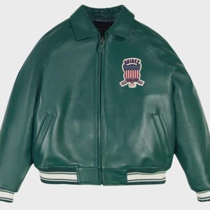 May include: A green leather jacket with a zip-up front, collared neckline, and ribbed cuffs and hem. The jacket features a patch on the chest with the text "AVIREX" and a design incorporating the American flag.