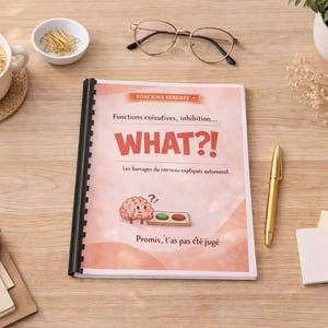 Peut inclure: Un livre avec le mot "WHAT?!" sur la couverture, avec du texte en français et une illustration de cerveau. Une tasse de café, des lunettes, un stylo et de la papeterie sont sur une surface en bois.