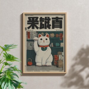 以下が含まれることがあります： 赤い首輪と鈴をつけた白い招き猫が描かれた額入りポスター。背景には様々な物が置かれた濃い緑色の棚があり、中央に猫が配置されている。プリントの上部には大きな黒い日本語の文字と小さなテキストが表示されている。
