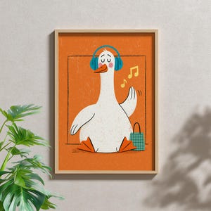 May include: A framed wall art print featuring a white goose with orange feet and beak, wearing blue headphones. The goose has its eyes closed and is positioned against a textured orange background with yellow musical notes and a small green bag.