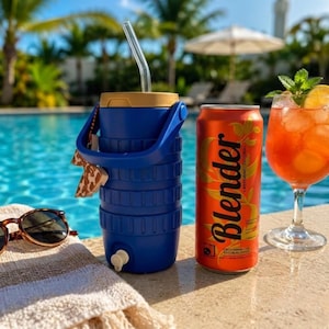 May include: A blue insulated beverage cooler with a tan lid, a handle, and a clear straw, positioned next to an orange aluminum can labeled Blender with leaf graphics, and a glass of orange liquid with ice and a mint sprig garnish.