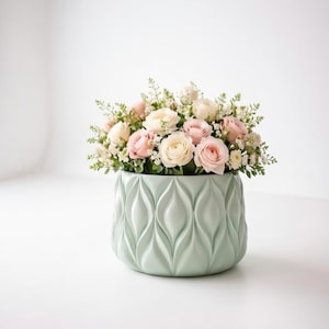 Può includere: Una tazza di ceramica bianca con manico nero e la scritta "But First, Coffee" in grassetto nero. La tazza è posta su uno sfondo sfocato, che suggerisce un'atmosfera accogliente.