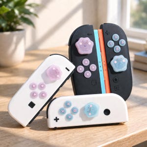 Può includere: Tre controller per videogiochi. Due sono bianchi e uno nero. Ogni controller ha un pulsante a forma di zampa e altri pulsanti in tonalità viola e blu. I controller sono su una superficie di legno.