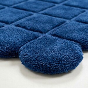 and large windows bringing natural light into the space. The handcrafted tufted rug has a distinctive curved edge design that makes it different from traditional rectangular rugs,