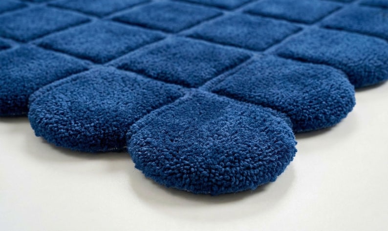 and large windows bringing natural light into the space. The handcrafted tufted rug has a distinctive curved edge design that makes it different from traditional rectangular rugs,