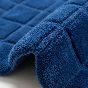 texture and contemporary pattern that adds elegance and comfort to modern home decor. The deep navy blue color of the rug creates a bold statement while blending