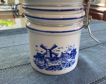 Jarra de cerámica vintage Teleflora Delft con forma de molino de viento, tapa metálica con bisagra y junta, color azul y blanco.
