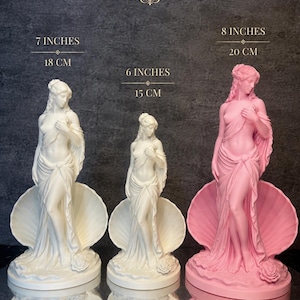 May include: Three statues of a figure standing in a seashell, one pink and one white. The pink statue is 20 cm (8 inches) tall, and the white statue is 15 cm (6 inches) and 18 cm (7 inches) tall. All figures have draped fabric, detailed hair, and a rose at the base.