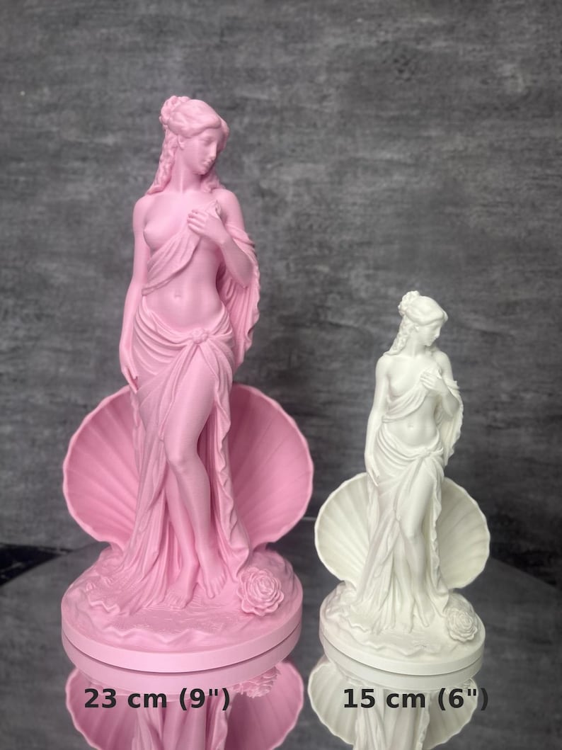 Op de afbeelding: Twee beelden van een figuur in een schelp, &eacute;&eacute;n roze en &eacute;&eacute;n wit. Het roze beeld is 23 cm hoog en het witte beeld is 15 cm hoog. Beide figuren hebben gedrapeerde stof, gedetailleerd haar en een roos aan de basis van de schelp.