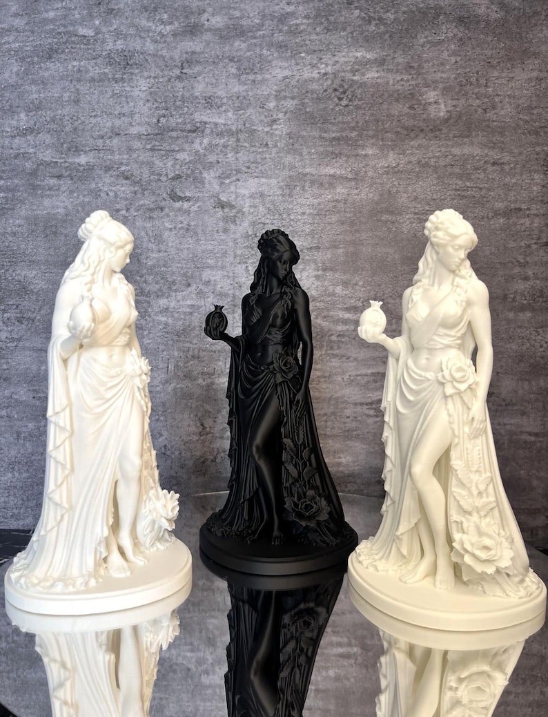 Three Persephone Statue color display featuring a matte black sculpture surrounded by two white versions, showcasing available finishes and size options. This elegant Greek Goddess figurine with a symbolic pomegranate and detailed floral design is inspired by Greek mythology and makes a beautiful pagan altar decoration, mythology collectible, gothic home decor piece, or meaningful gift.