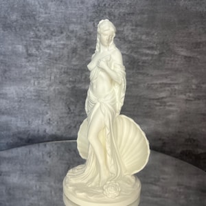 Final front angle / close perspective
Detailed front angle of Venus / Aphrodite figurine featuring graceful feminine pose and shell symbolism. Greek and Roman mythology inspired decor, white goddess sculpture for altars, shelves, vanities, spiritual spaces, divine feminine decor, romantic home styling, mythology gift, aesthetic PLA statue, elegant collectible artwork.