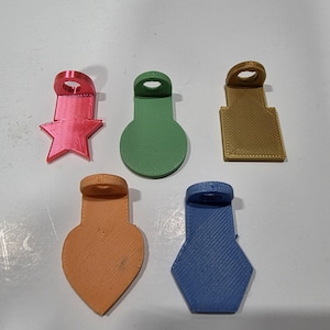 May include: A set of three ceramic mugs with a speckled, matte finish. The mugs are in shades of cream, light gray, and dark gray. Each mug has a simple, minimalist design and a rounded handle.
