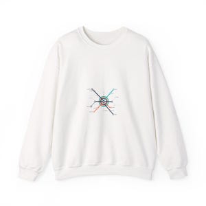 Op de afbeelding: Witte crewneck sweatshirt met een kleurrijk metrokaartontwerp. De afbeelding toont een centrale cirkelvormige hub met lijnen die in verschillende kleuren naar buiten stralen, waaronder rood, blauw en groen. De sweatshirt is gemaakt van een zacht materiaal.