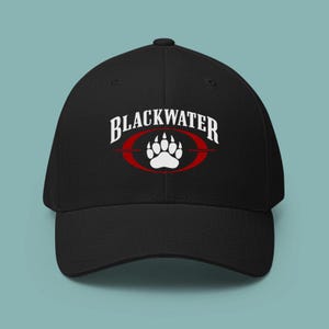 May include: A black baseball cap featuring a white bear paw print graphic centered inside a red oval. The word BLACKWATER is printed in white capital letters in an arched font above the red oval and white bear paw print design.