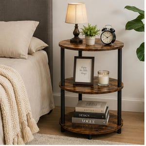 May include: A three-tiered, round side table with a dark brown, wood-look finish. The table has black metal supports and holds a lamp, a small potted plant, a framed print with the text "Enjoy the little things", a candle, and books.