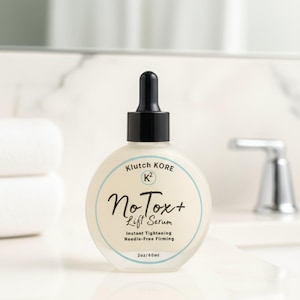 May include: A round, frosted glass bottle of No Tox+ Lift Serum with a black dropper top. The label features the text "Klutch Kore" and "No Tox+ Lift Serum". The bottle contains 2oz/60ml of product.