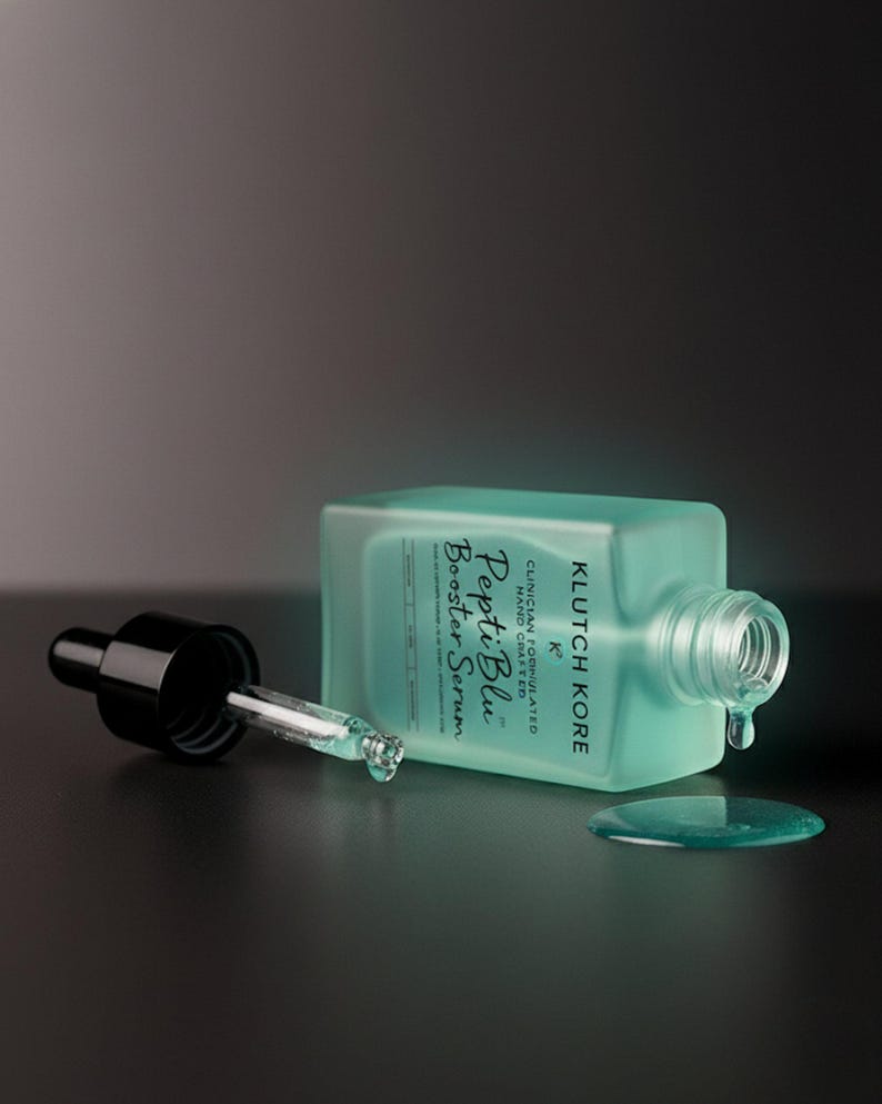 Puede incluir: Una botella turquesa de Pepti Blue Booster Serum con un cuentagotas negro y un peque&ntilde;o charco de suero. La botella est&aacute; tumbada de lado, con el cuentagotas separado. El texto "Pepti Blue Booster Serum" es visible.