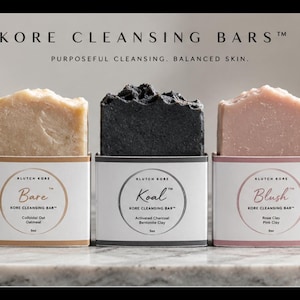 May include: Five rectangular cleansing bars labeled Kore Cleansing Bars. The bars are white, beige, black, pink, and purple, each in a white paper sleeve with circular labels reading NeKKeT, Bare, Koal, Blush, and Ameth, with 5oz printed below.