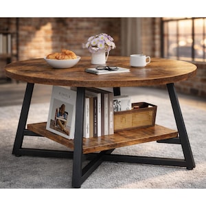 May include: A round coffee table with a distressed wood top and a lower shelf. The table has black metal legs and is styled with books, a magazine, a white bowl with pastries, a mug, and a small basket.