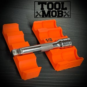 Può includere: Organizzatore di utensili arancione brillante con una chiave a bussola da 1/2 pollice. L'organizzatore ha un design a gradini per tenere gli utensili in modo sicuro. Il testo "TOOL MOBX" si trova nell'angolo in alto a destra.