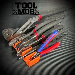 May include: An assortment of hand tools, including pliers and wrenches, arranged on an orange holder. The tools have black handles with red accents. The image includes the text "TOOL MOBX" in the upper left corner.