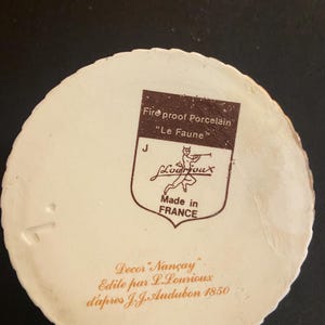 May include: A white ceramic mug with a black handle and the text "But First, Coffee" in a black, handwritten-style font. The mug is on a white surface.