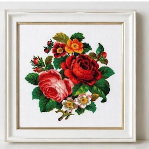 Può includere: Ricamo a punto croce di fiori in una cornice bianca. L'opera presenta un bouquet di rose rosse, rosa e gialle con foglie verdi. Il pezzo incorniciato è di forma quadrata e si trova su uno sfondo bianco.