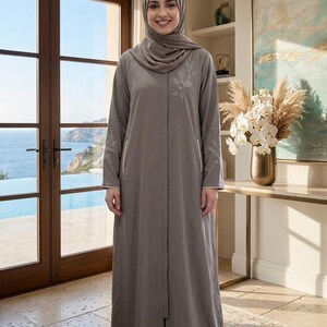 grey dress matching hijab Eid26 by Alara Designs , A timeless grey throw layered over a sleek inner dress, perfectly finished with a matching hijab the ultimate Eid Abaya for the woman who embodies effortless elegance.,