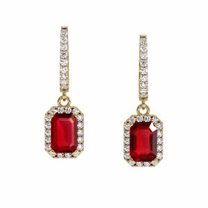 May include: A pair of drop earrings featuring rectangular, deep red gemstones set in gold. Each earring has a vertical bar encrusted with small, clear white stones leading to a central rectangular red stone surrounded by a halo of clear white stones.