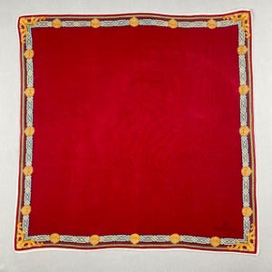 Peut inclure: Un foulard carré rouge avec une bordure décorative. La bordure présente des médaillons dorés et des motifs d'angle dorés ornés. Le foulard a une bordure blanche avec un motif doré et sarcelle.