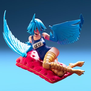 May include: A figurine of a blue-haired character with bird-like features, wearing a blue swimsuit with Japanese text. The figure is posed on a red cushion with blue wings extended. The character's legs are yellow with a honeycomb pattern.