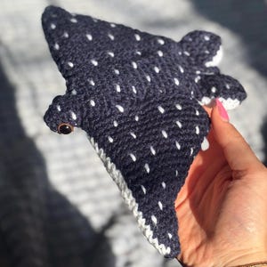 K&ouml;nnte beinhalten: Geh&auml;keltes Walhai-Pl&uuml;schtier in Marineblau mit wei&szlig;en Punkten. Das Kuscheltier hat einen wei&szlig;en Rand und ein braunes Auge. Dieses handgefertigte Spielzeug ist ein Unikat.