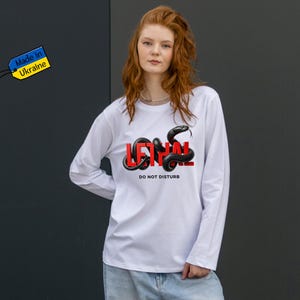 Może przedstawiać: Zestaw trzech ceramicznych kubków z nakrapianym, matowym wykończeniem. Kubki są w odcieniach kremu, jasnoszarym i ciemnoszarym. Każdy kubek ma prosty, minimalistyczny design.