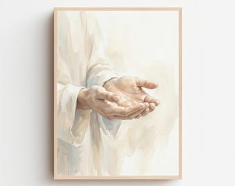 May include: Watercolor print of open hands, palms up, in a light-colored robe. The artwork is framed in a light wood frame, set against a soft, neutral background. The hands are the focal point, rendered with detailed shading.