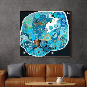 Puede incluir: Una impresión artística abstracta enmarcada con un diseño complejo de círculos interconectados en tonos de azul, verde azulado y marrón. La obra de arte tiene un fondo oscuro y está montada en un marco dorado.