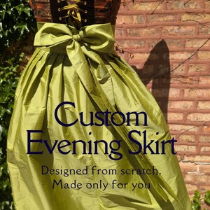 May include: A custom evening skirt with a corset top and a flowing, pleated skirt. The corset is brown and gold with a lace-up front. The skirt is a vibrant green with a large bow at the waist. Text on the skirt reads "Custom Evening Skirt."