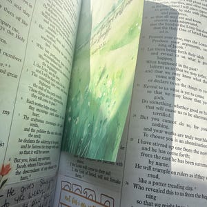May include: An open Bible with thin pages featuring printed text in columns. A green watercolor bookmark with the text "They that wait upon the Lord shall renew their strength" and "Isaiah 40:31" is inserted. A stamp reads "not for i am with you" and "Isaiah 41:10".