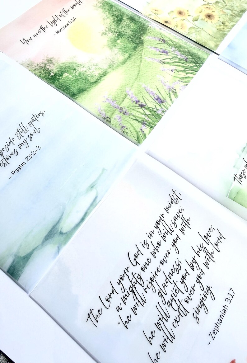 May include: A collection of watercolor art cards with inspirational quotes and Bible verses. The cards feature soft pastel colors and floral illustrations. The text includes verses from Matthew, Psalm, and Zephaniah.