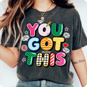 May include: A white ceramic mug with a black handle and the text "But First, Coffee" in a black, handwritten-style font. The mug is on a white surface.