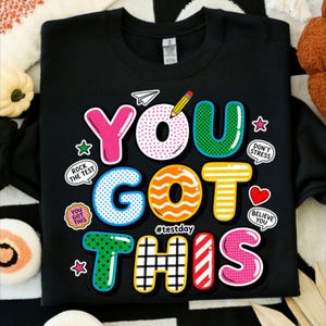 May include: A set of three ceramic mugs with a speckled, matte finish. The mugs are in shades of cream, light gray, and dark gray. Each mug has a simple, minimalist design and a rounded handle.