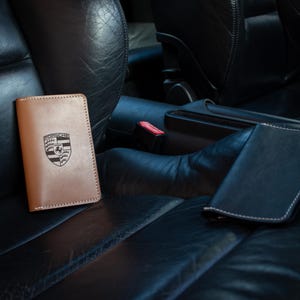 Op de afbeelding: Een witte keramische mok met een zwart handvat en de tekst "But First, Coffee" in een zwarte, vette letter. De mok staat op een wit oppervlak. De mok is ongeveer 10 cm hoog.