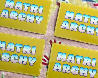 Matriarchy sticker with Trans Pride colors and yellow background
